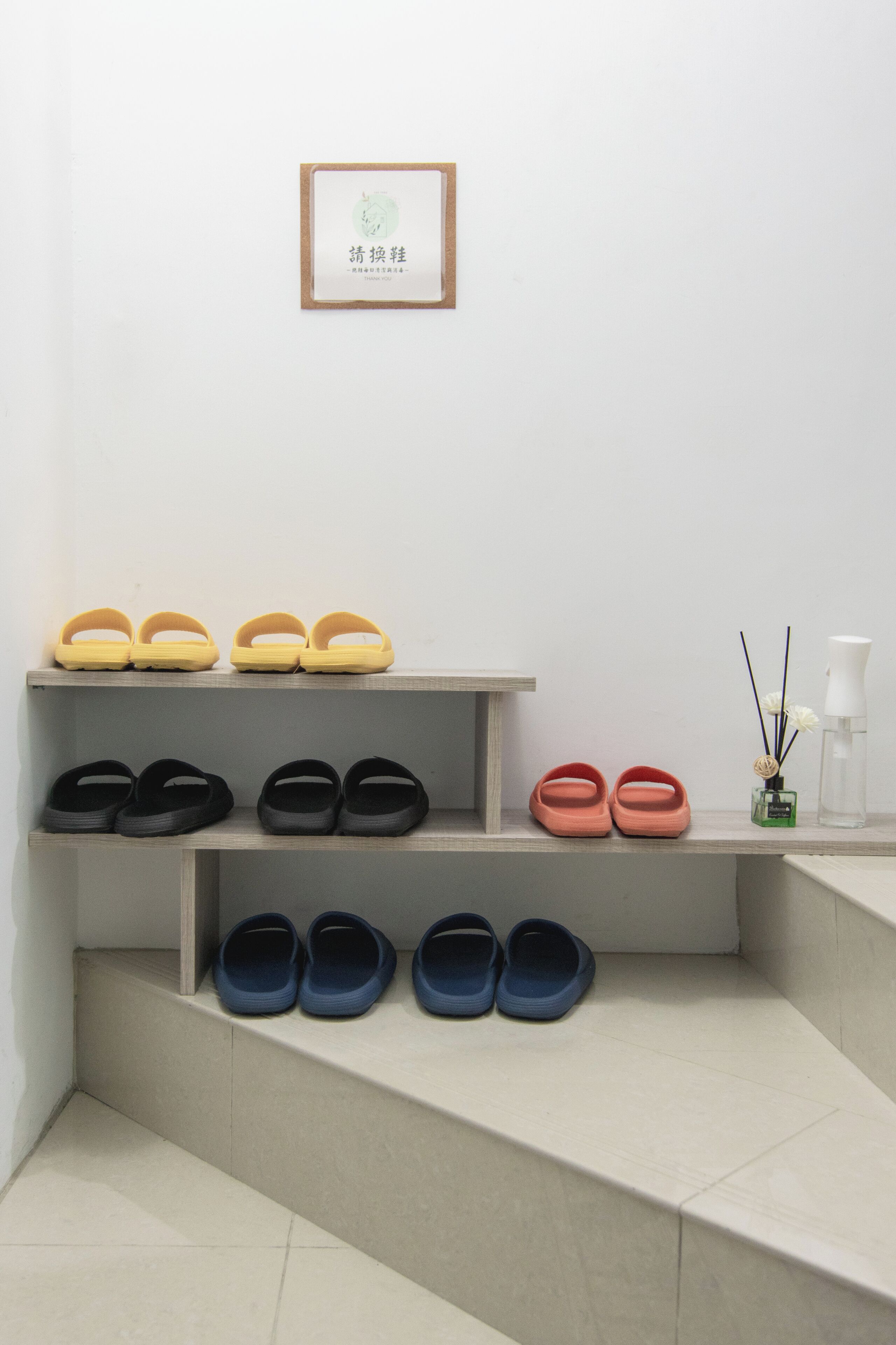 綠院食蔭樓梯邊的階梯式鞋架、室內拖鞋及換鞋告示。