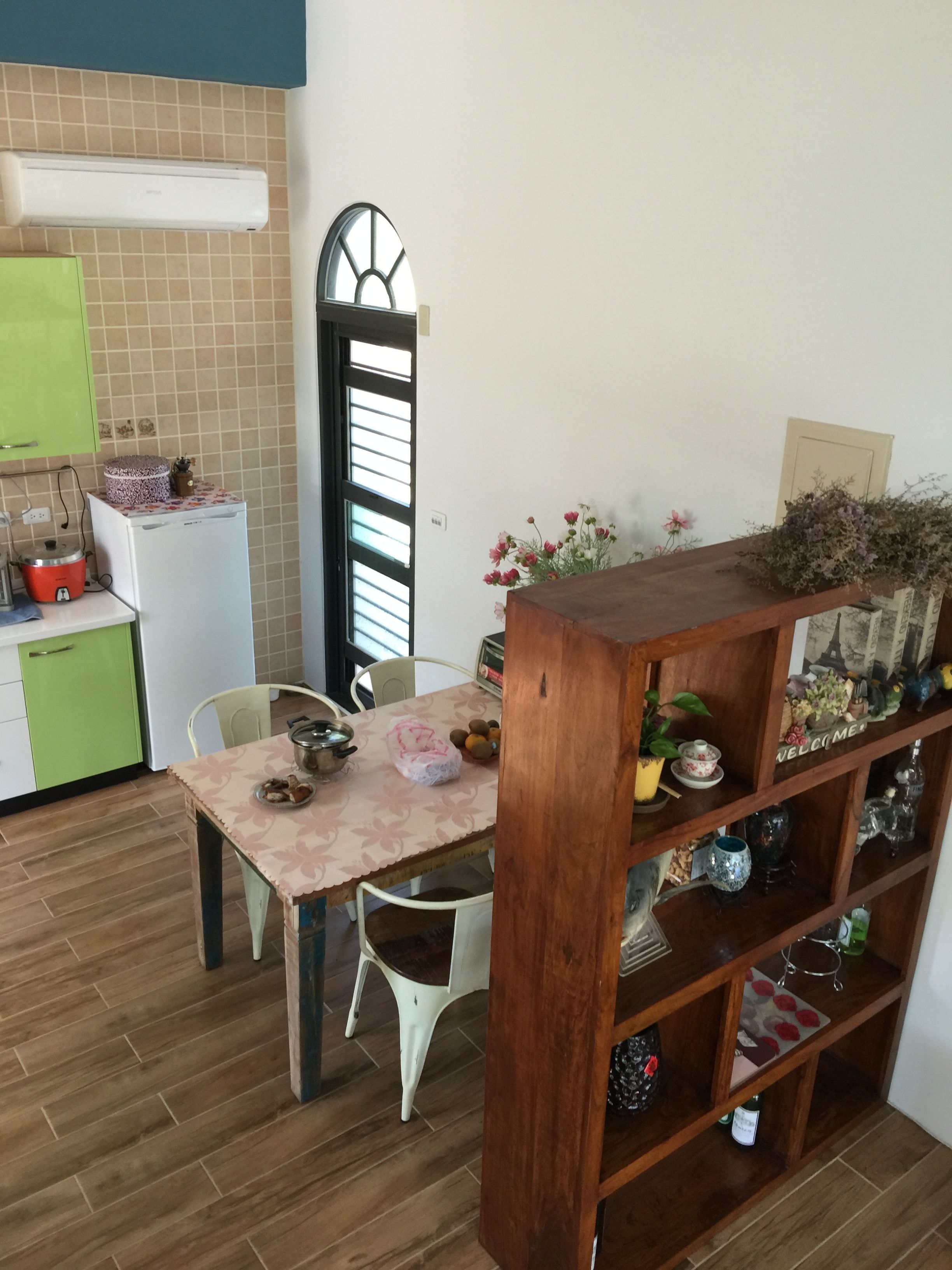 吾居吾素用餐角落的綠色櫥櫃、白冰箱、花布餐桌與展示櫃。